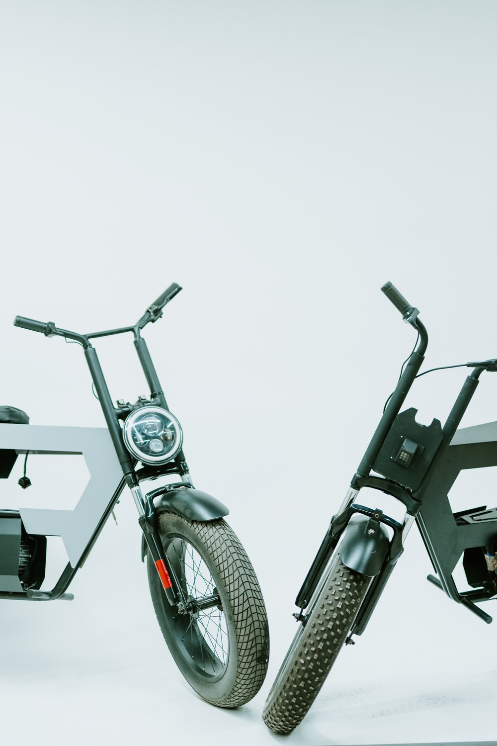 Two Axiomea electric vehicle platforms — a bare engineering chassis beside a built-up vehicle